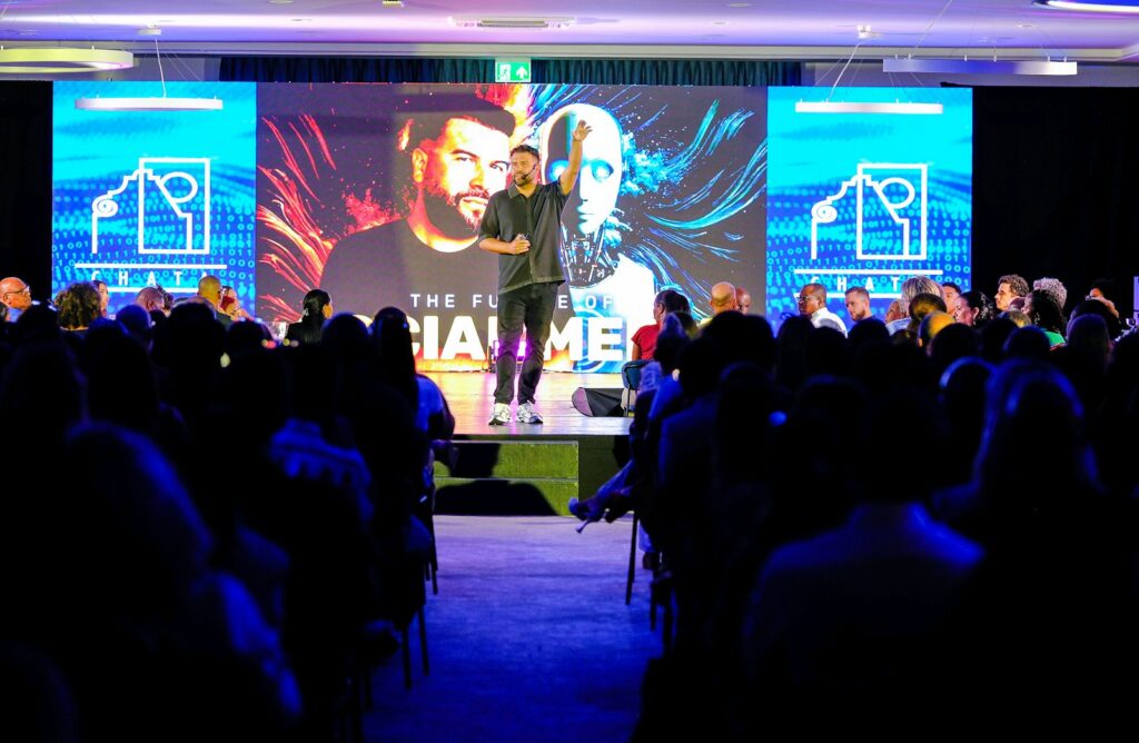 Speaker on stage addressing a conference audience, representing celebrity booking for company events