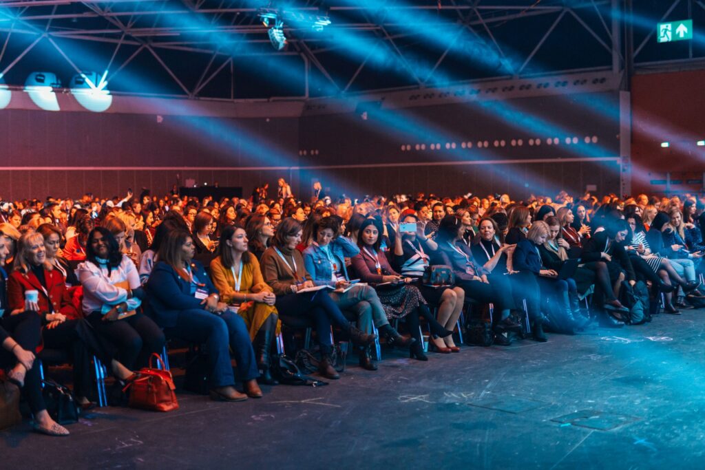 When to approach sponsors: conference audience under blue stage lighting